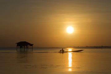 Fishermen and fishing boats float in the lake.