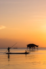 Fishermen and fishing boats float in the lake.