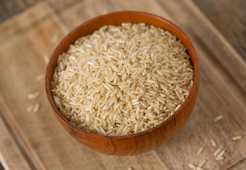 Brown rice in a bowl on wooden ыгкафсу