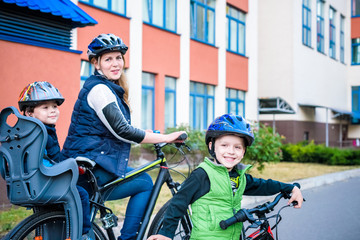 Obraz premium Family cycling, mother with happy kid riding bike outdoors