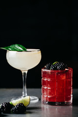Two alcoholic cocktails with black negative space