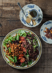 A gourmet salad on rustic surface, vertical, top view