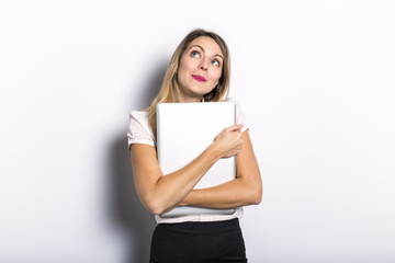 Young business woman offers computer product, on grey background