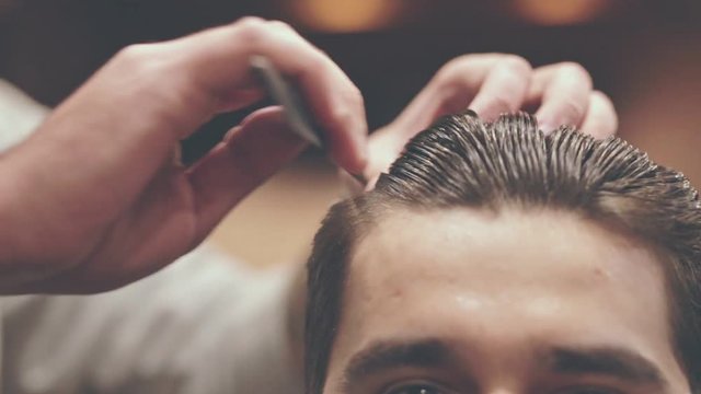 Man combing hair. Close up of barber comb hair. Male hairstyle. Hairdresser styling hair. Hair fashion model. Man hairstyle. Barber haircut. Hairdressing style. Hairstyle man