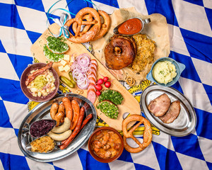 Oktoberfest food frame concept. a set of snacks for beer for Oktoberfest on white blue flag