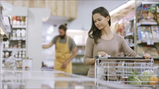  Customer shopping in frozen food aisle of supermarket
