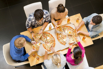 Group of young people eating pizza and drinking cider
