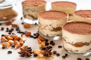 Homemade tiramisu, traditional Italian dessert in glass on white wooden table