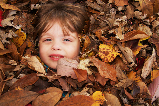 Kid in pile of leaves