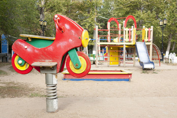 Children's playground in the courtyard of the house (swings, slides).  Bright, juicy photos of a children's playground in the courtyard of a residential building. Children swing, carabolic.