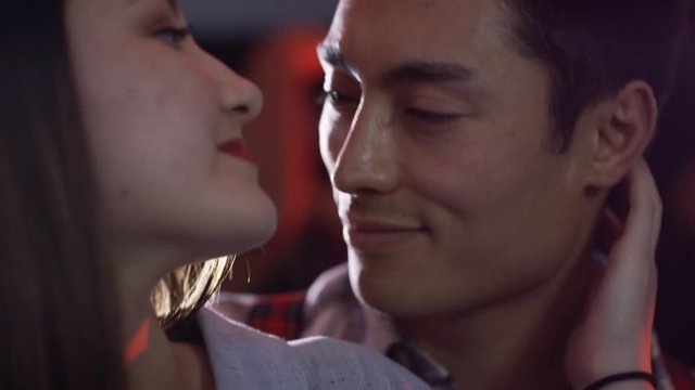 Close up portrait young couple dancing and flirting at party or night club