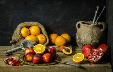 Classic still life with fresh delicious autumn fruits paced with old jar and knife on rustic wooden background