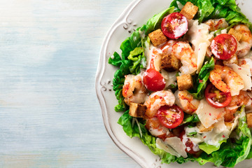 Closeup photo of shrimp Caesar salad with copyspace