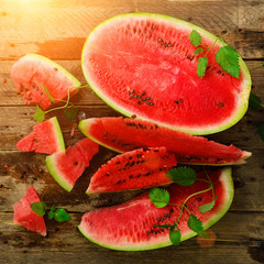 Slices of watermelon with mint leaves on wooden background. Detox and vegetarian concept. Top view, flat lay, copy space