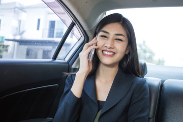 Fototapeta na wymiar Woman using Smartphone for working in car with attractive smiling, Woman working concept.