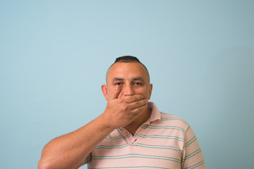 man covers his mouth with his hands, fear, does not want to roar, laughing