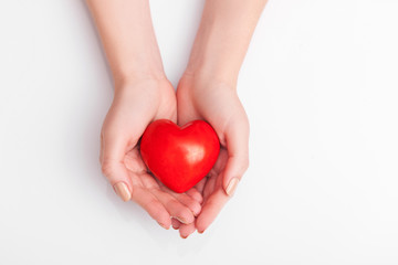 People, relationship and love concept - close up of womans cupped hands showing red heart