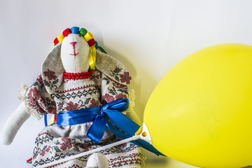 The doll is a guard in a national costume with ribbons and a yellow ball.