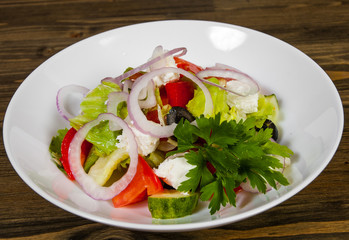 vegetable salad with cheese, cabbage, pepper, tomato and cucumber on wooden table.