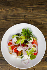 vegetable salad with cheese, cabbage, pepper, tomato and cucumber on wooden table. with copy space. top view