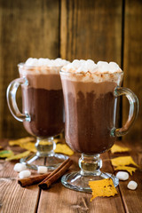 Hot chocolate with marshmallow in glass cups on wooden background