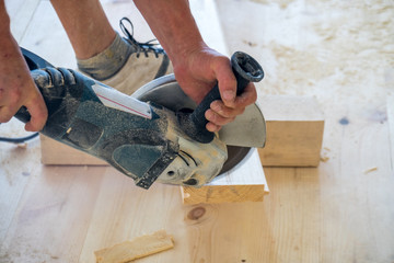 Man using a circular saw to cut floor material