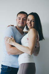 Fototapeta premium beautiful young couple hugging and smiling on white background