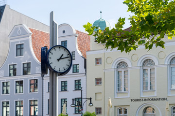 Fototapeta na wymiar clock in the city of Rostock - old hanse buildings in the background