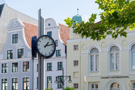 clock in the city of Rostock - old hanse buildings in the background