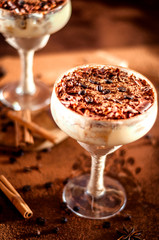 luxurious dessert Tiramisu in a glass with coffee beans on a dark background