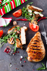 Grilled chicken fillets on slate plate.