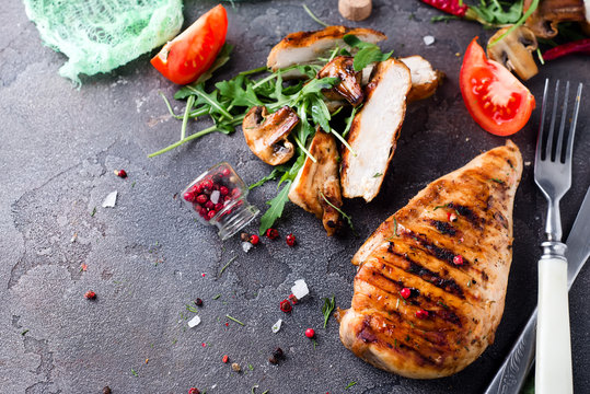 Grilled chicken fillets on slate plate.