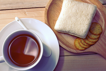 Cup of tea with bread and snack.
