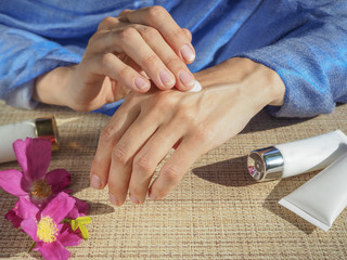 Woman hands applying moisturizing cream to her skin. 