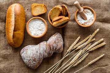 Fototapeta na wymiar fresh bread with wheat flour in bakery shop on linen background top view