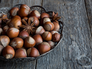 Hazelnuts in openwork plate on teriann background rustic
