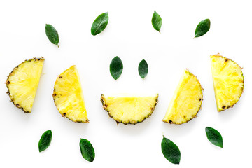 Pattern of pinneapple slices and leaves on white background top view