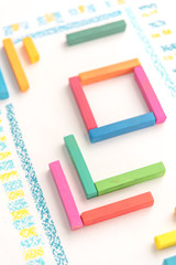 Cropped photo of a cute geometric pattern made of colorful kid's pastel chalks