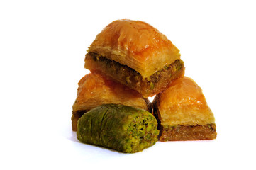 Baklava with pistachios, walnuts and honey on white background.
