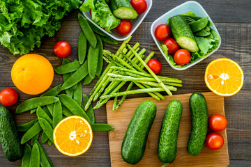 Healthy meal in containers. Salad with tomato and cucumber in cotainers on wooden background top view