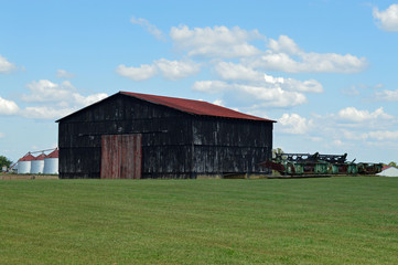 Old barn and old farm machinery in a rural landscape setting