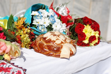 Ukrainian festive bread with bouquets of flowers on the table