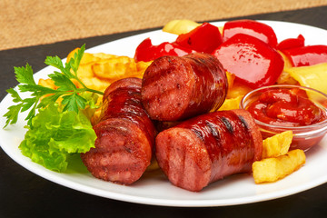 grilled sausages with potatoes fries and sweet bulgarian peppers and red sauce ketchup