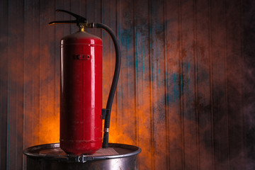 Fire extinguisher on old rusty barrel