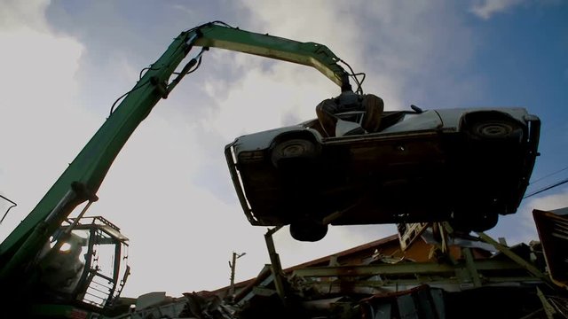 Cranes with hydraulic gripper moving cars for recycling