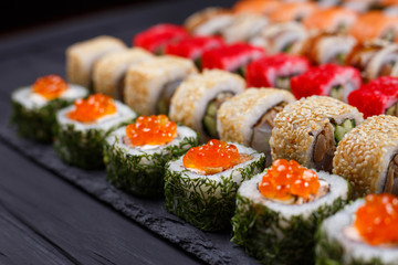 Japanese food, sushi restaurant. Great assortment of tasty multicolored maki sushi rolls, selective focus