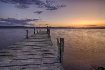 Beauty and calm sunset on lake with wooden pier