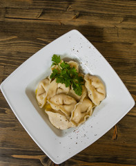 Meat dumplings - russian pelmeni, ravioli with meat on a wooden background. with copy space. top view