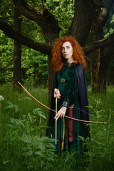 Red haired girl shoots from the bow