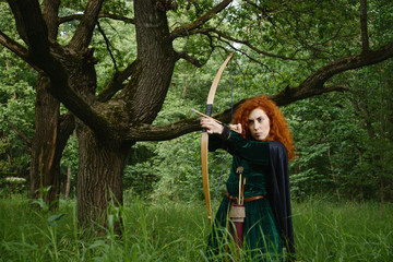 Red haired girl shoots from the bow